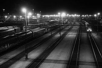 Nighttime Train Yard with Tracks and Streetlights