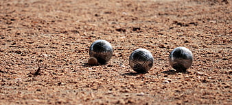 Petanque balls and jack on gravel court