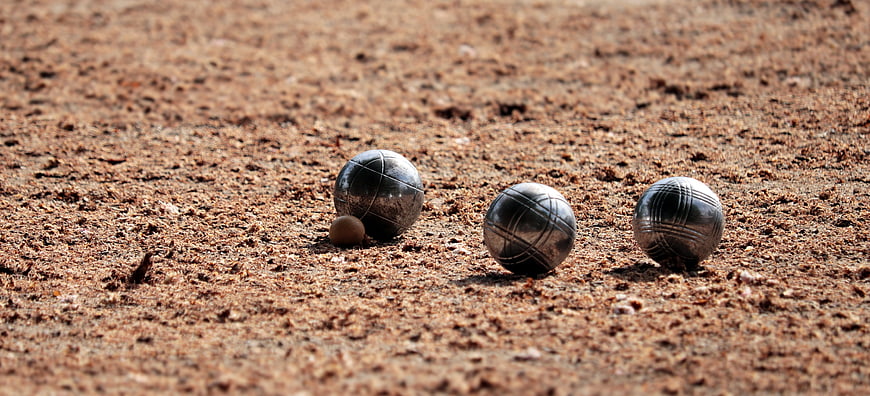Petanque balls and jack on gravel court