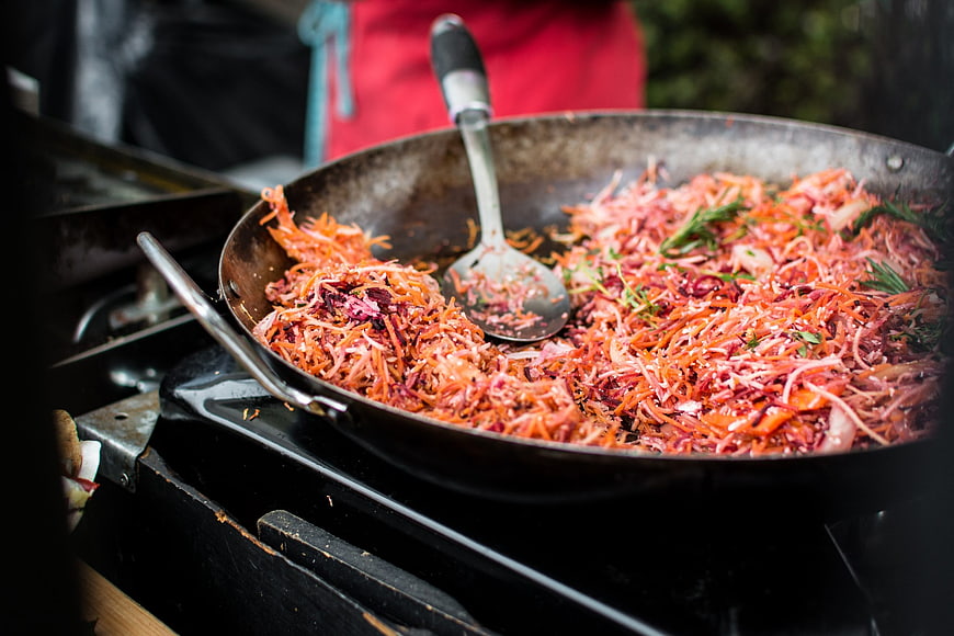 Stir-fried shredded carrots and beets in a frying pan