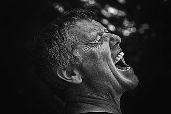 Black and white portrait of a man screaming in the rain