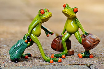 Cute ceramic frog figurines with luggage walking on pavement