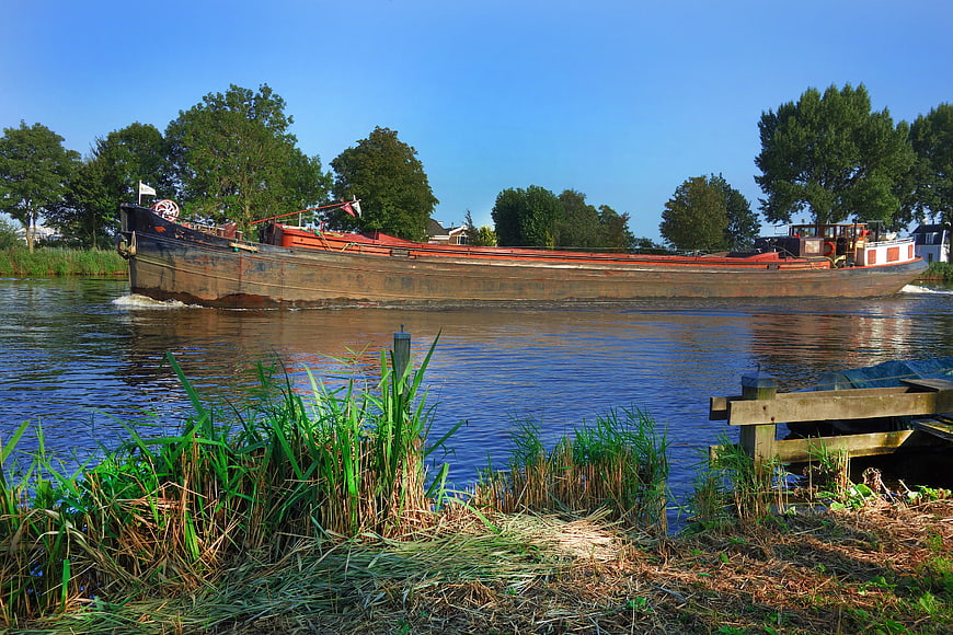 Traditional wooden barge sailing on a calm river