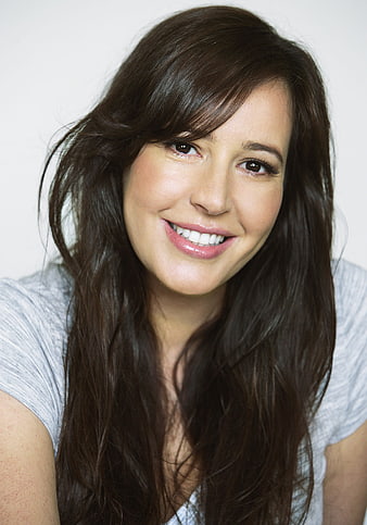 Smiling young woman with long dark hair in a gray t-shirt