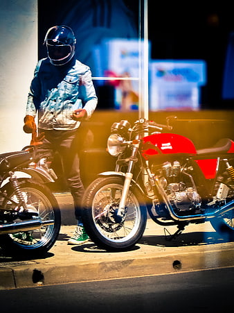 Man in Helmet Standing Next to Red Motorcycle at Night