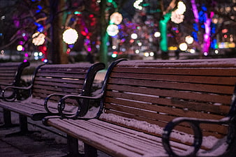 Snowy Park Benches with Colorful Bokeh Lights at Night
