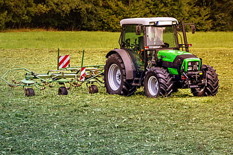 Green Tractor Mowing Grass in Pasture Field
