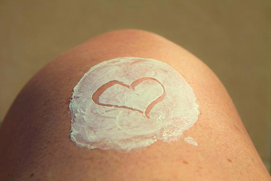 Heart shape drawn in sunscreen cream on skin