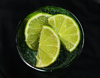 Top-down view of lime slices in sparkling water glass
