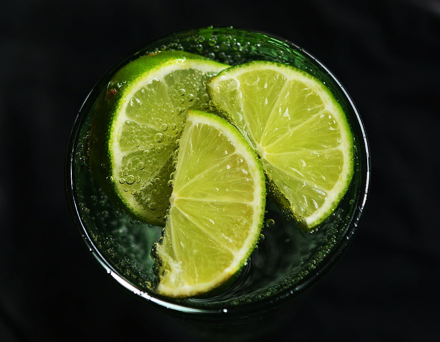 Top-down view of lime slices in sparkling water glass
