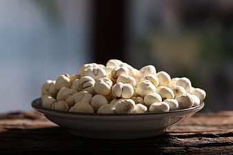 Bowl of Dried Lotus Seeds on Rustic Wooden Table