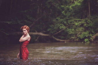 Woman in Red Dress Standing in Forest River