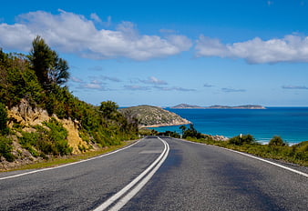 Winding coastal road leading to turquoise ocean and islands