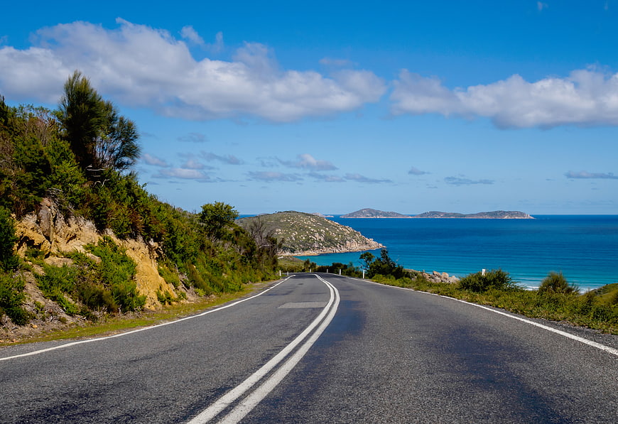 Winding coastal road leading to turquoise ocean and islands