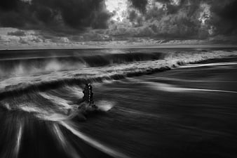 Dramatic black and white long exposure ocean waves crashing on beach