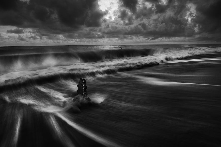 Dramatic black and white long exposure ocean waves crashing on beach