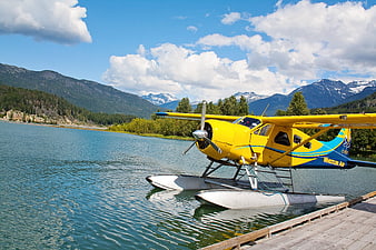 Yellow Seaplane Docked at Mountain Lake