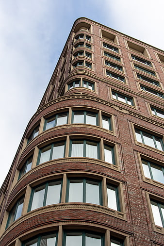 Low angle view of red brick building corner with curved windows