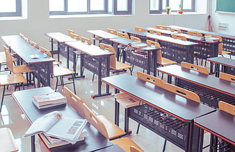 Empty modern classroom with rows of desks and textbooks