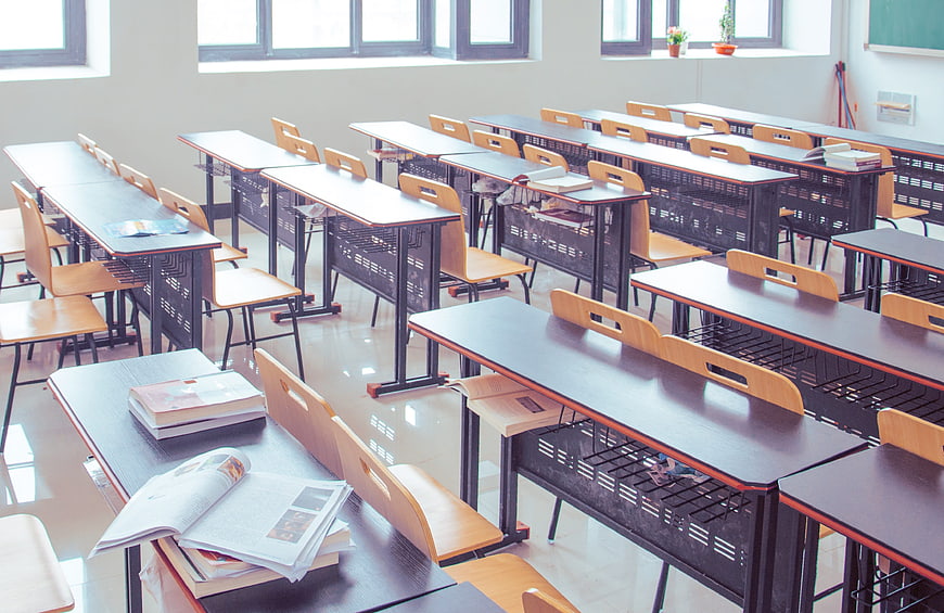 Empty modern classroom with rows of desks and textbooks