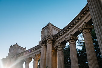 Low angle view of classical columns against blue sky