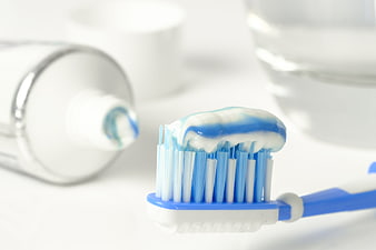 Blue and white toothbrush with toothpaste on bristles