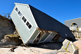 Damaged Beach House Collapsing into Erosion Cliff