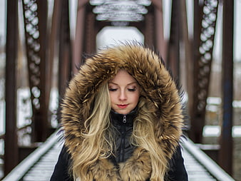 Blonde Woman in Fur Hooded Jacket on Winter Bridge