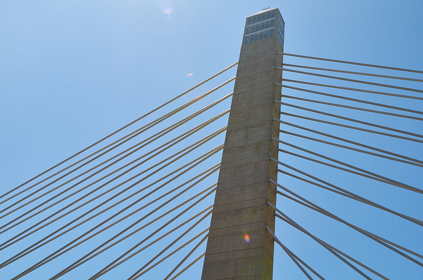 Low angle view of cable-stayed bridge tower against blue sky