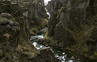 Moss-covered basalt cliffs in a narrow river canyon landscape