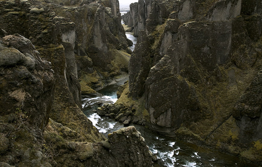 Moss-covered basalt cliffs in a narrow river canyon landscape