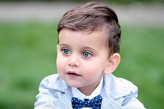 Portrait of a cute toddler boy with green eyes and bow tie