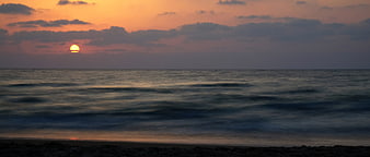 Long Exposure Ocean Sunset With Smooth Water And Dramatic Sky