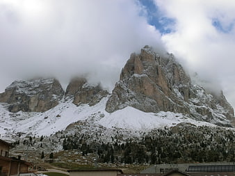 Snowy Dolomites Mountain Peak with Clouds and Village