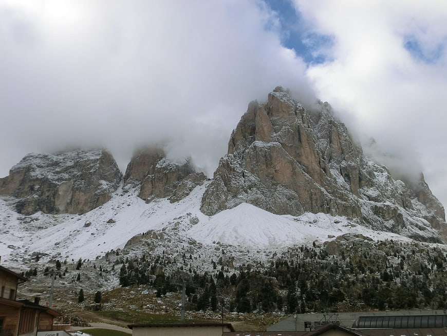 Snowy Dolomites Mountain Peak with Clouds and Village