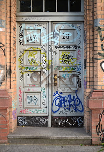 Weathered Double Door Covered in Colorful Graffiti