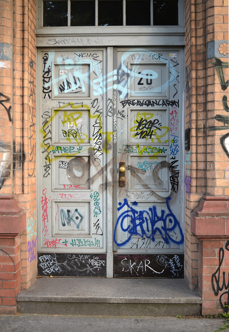 Weathered Double Door Covered in Colorful Graffiti