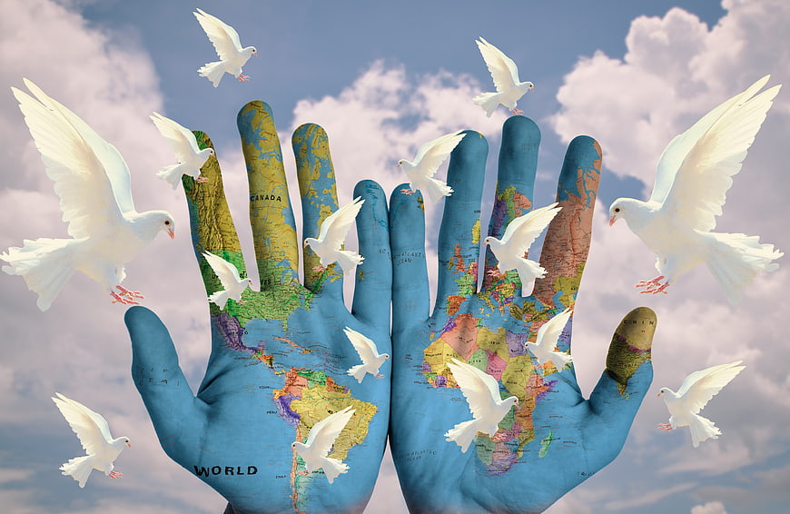 Hands with World Map and Flying White Doves Symbolizing Peace
