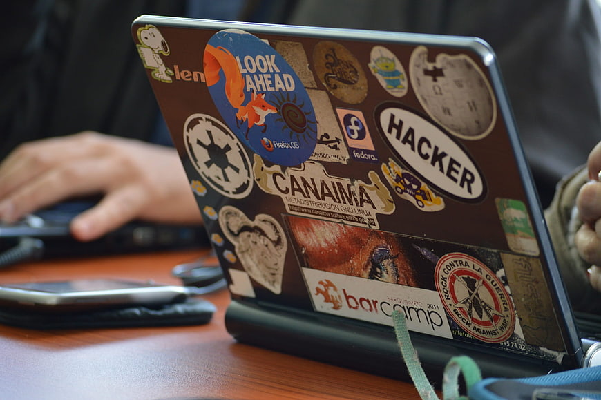 Laptop covered in open source and hacker stickers