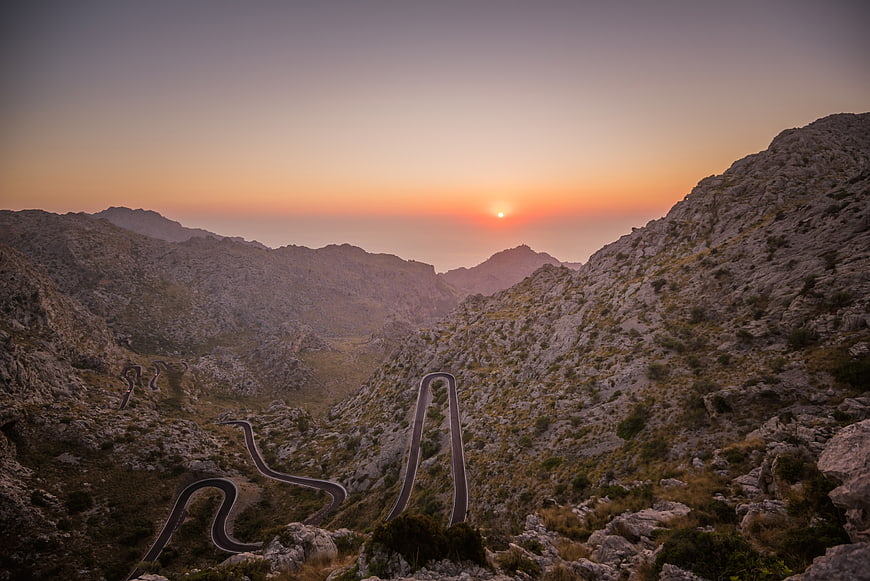 Winding Mountain Road at Sunset with Golden Sky