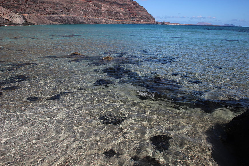 Crystal clear turquoise water with rocky seabed and cliffs