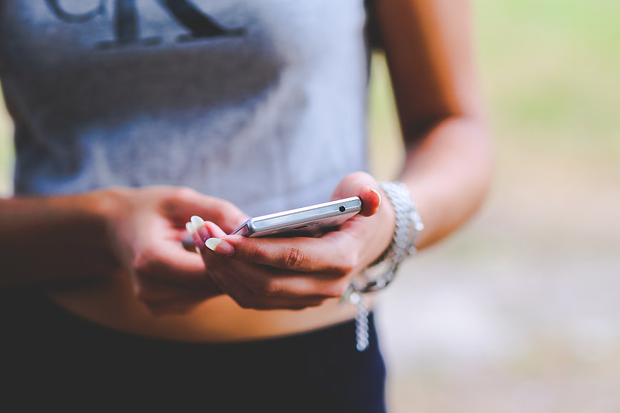 Close-up of Woman's Hands Using Smartphone Outdoors