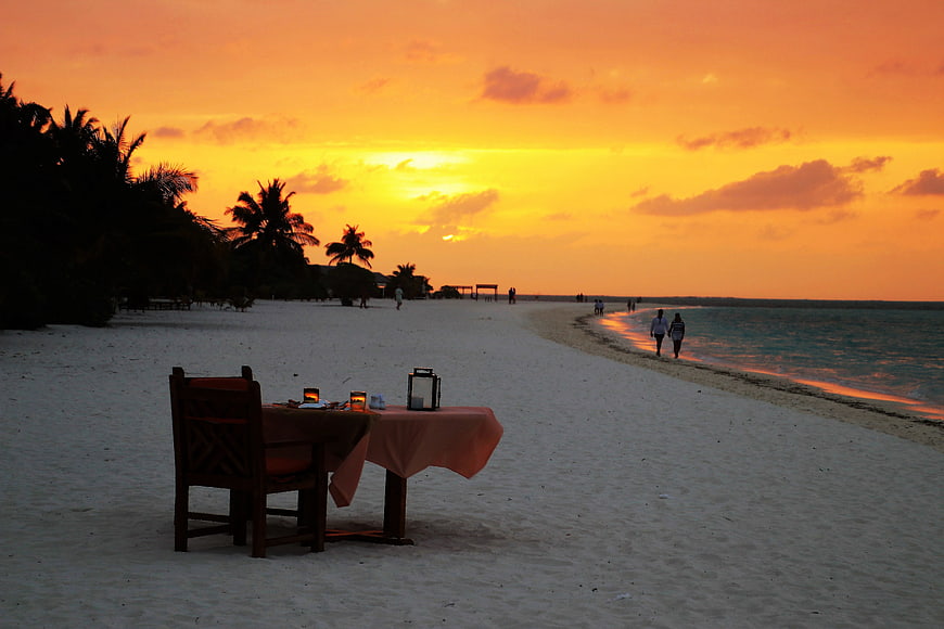 Romantic Beach Dinner Table at Sunset in Maldives