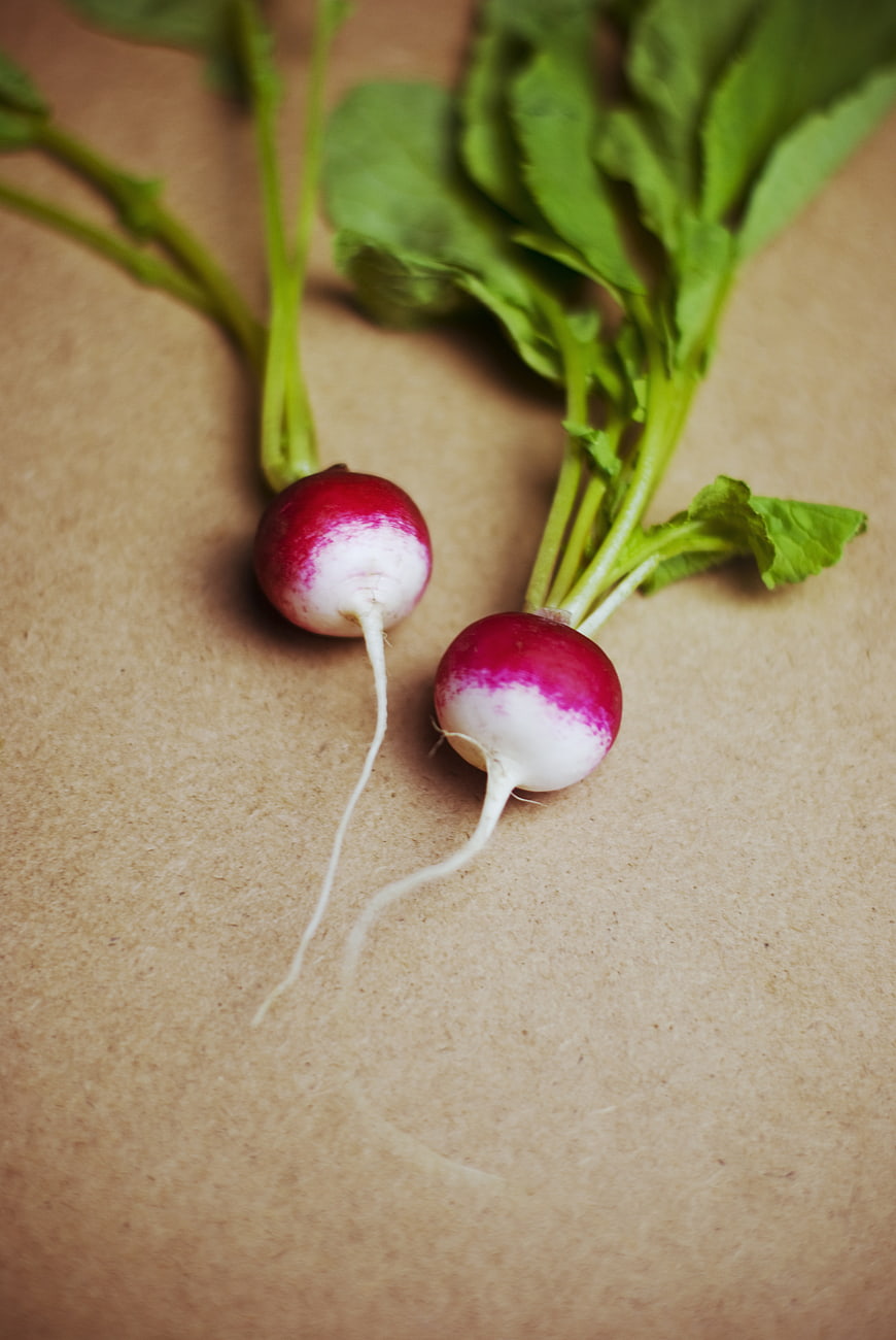 Fresh Radishes with Green Leaves on Brown Paper