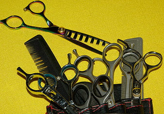 Professional Hairdressing Scissors and Combs on Yellow Background