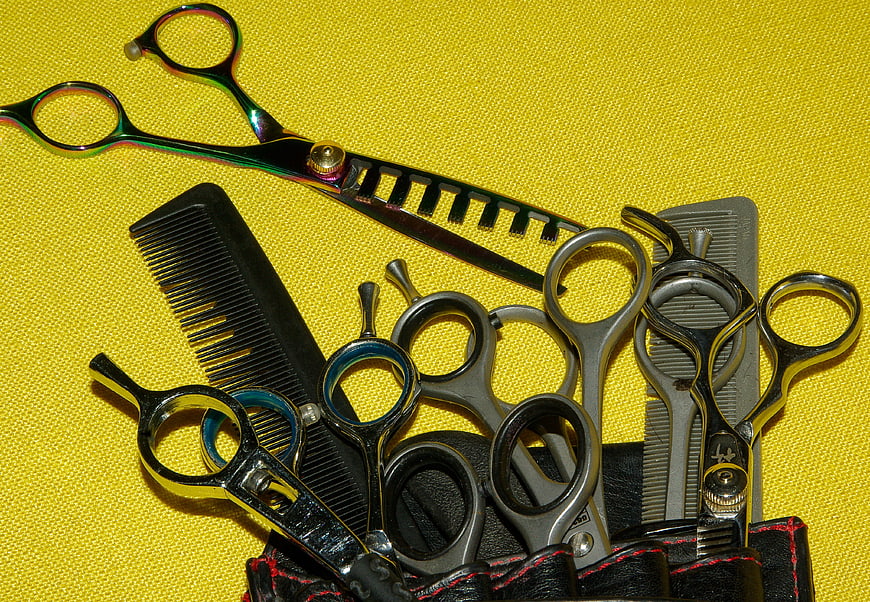 Professional Hairdressing Scissors and Combs on Yellow Background