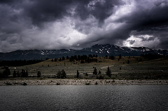 Dramatic storm clouds over mountain lake landscape