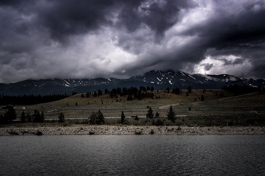 Dramatic storm clouds over mountain lake landscape