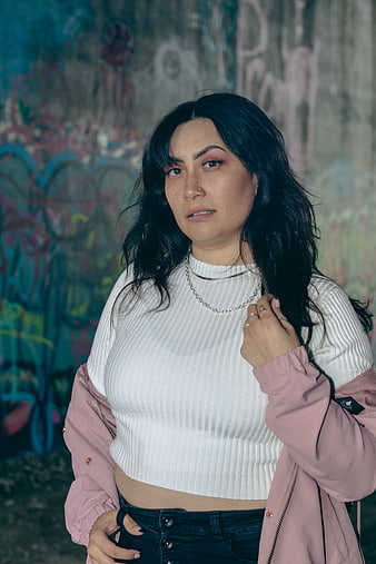 Woman in Pink Jacket Against Graffiti Wall