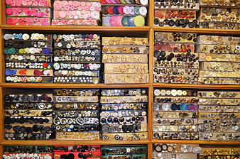 Organized wooden shelves filled with colorful vintage and modern sewing buttons